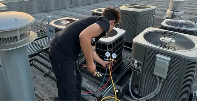 Technician servicing outdoor AC units
